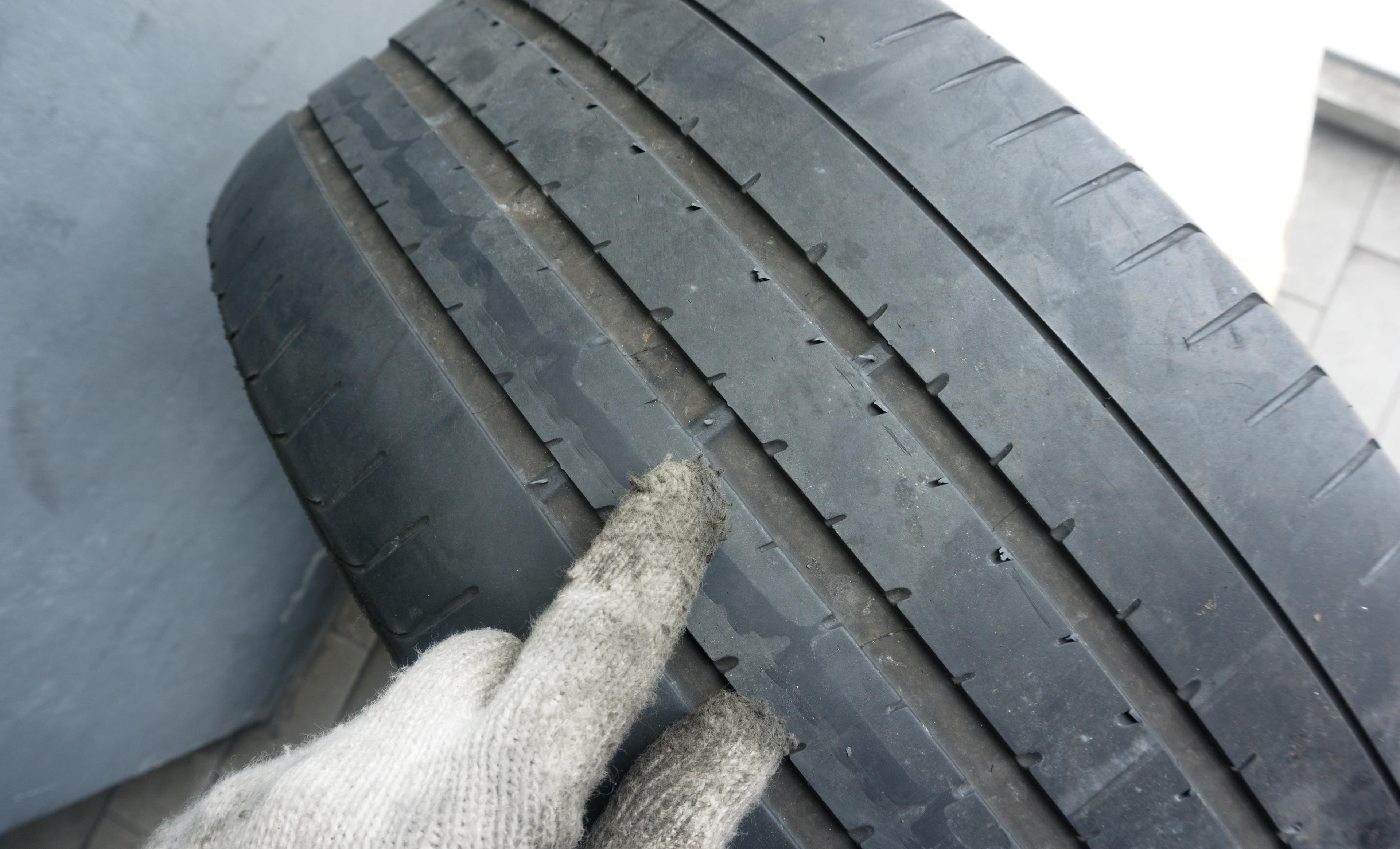 Mechanic Pointing to Tread Wear Bar Indicator on Tire